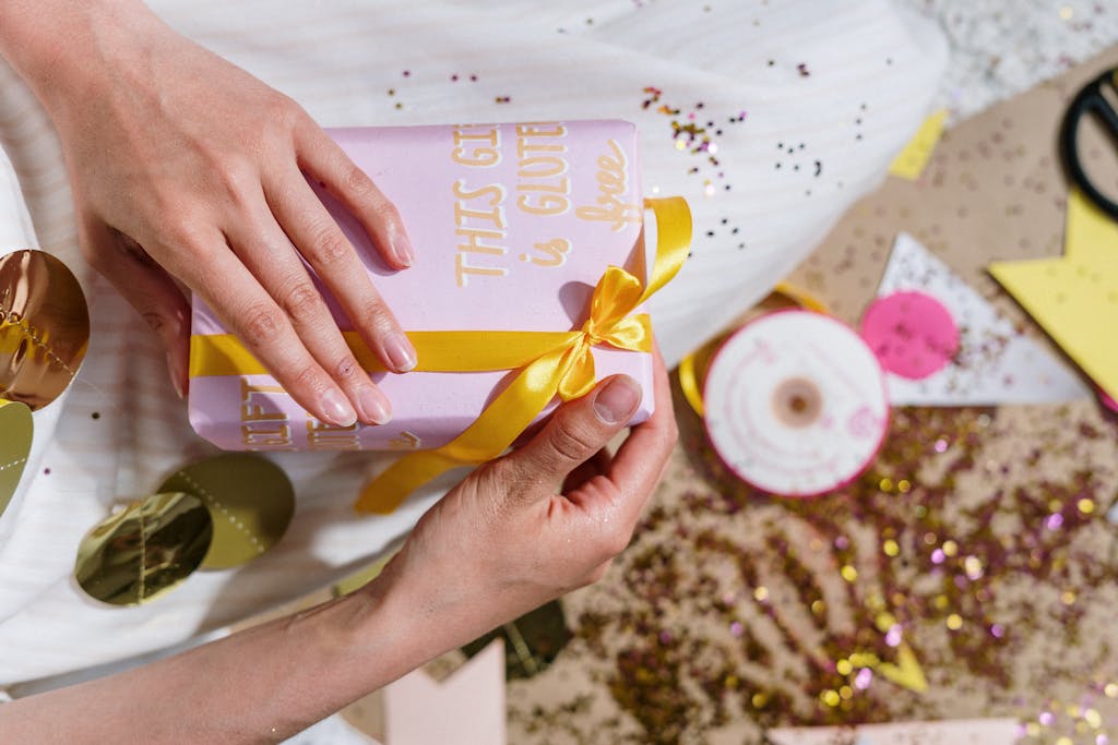 XSON208 A festive gift wrapped with a yellow ribbon and the message 'This gift is gluten-free' amidst sparkles and decorations.