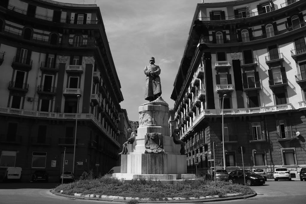 Black and white photo of the Umberto I statue in Naples with classical architecture.