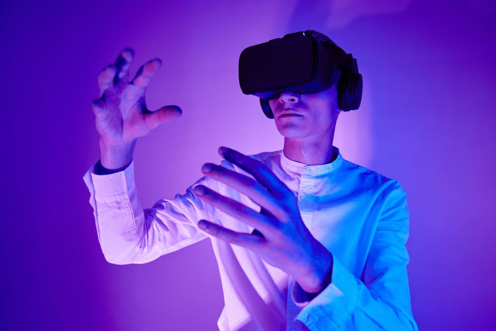 kongotech.blog A man wearing VR goggles interacts with a virtual environment in a studio shot with vibrant lighting.