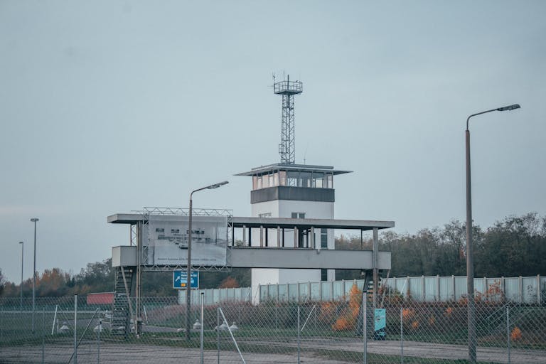 vrealize infrastructure navigator A modern control tower at an airport, surrounded by fences and street lamps.