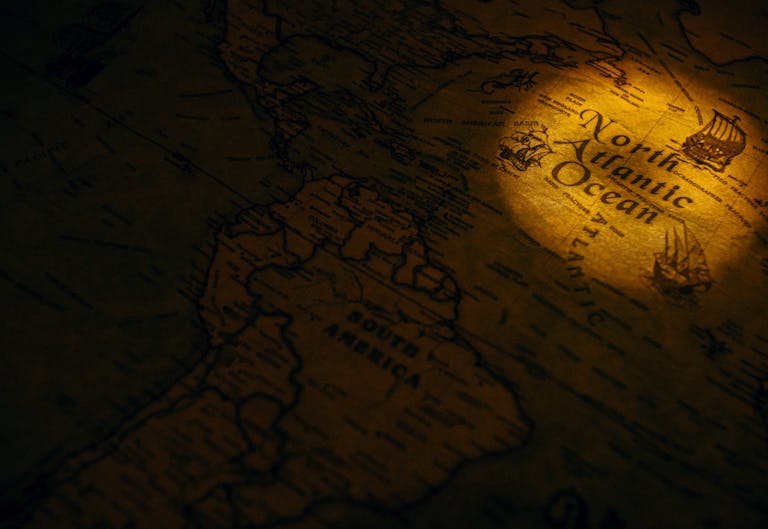 FamousParentingMomlife A vintage map highlighting the North Atlantic Ocean with a focused spotlight creating a dramatic effect.