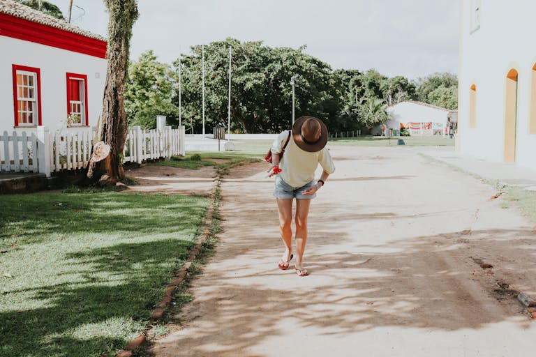 Eagles Rookie Trade Attempt Juntos Seguros ICEJuntos Seguros ICE A woman in casual attire walks down a sunny street in Porto Seguro, Bahia, Brazil.