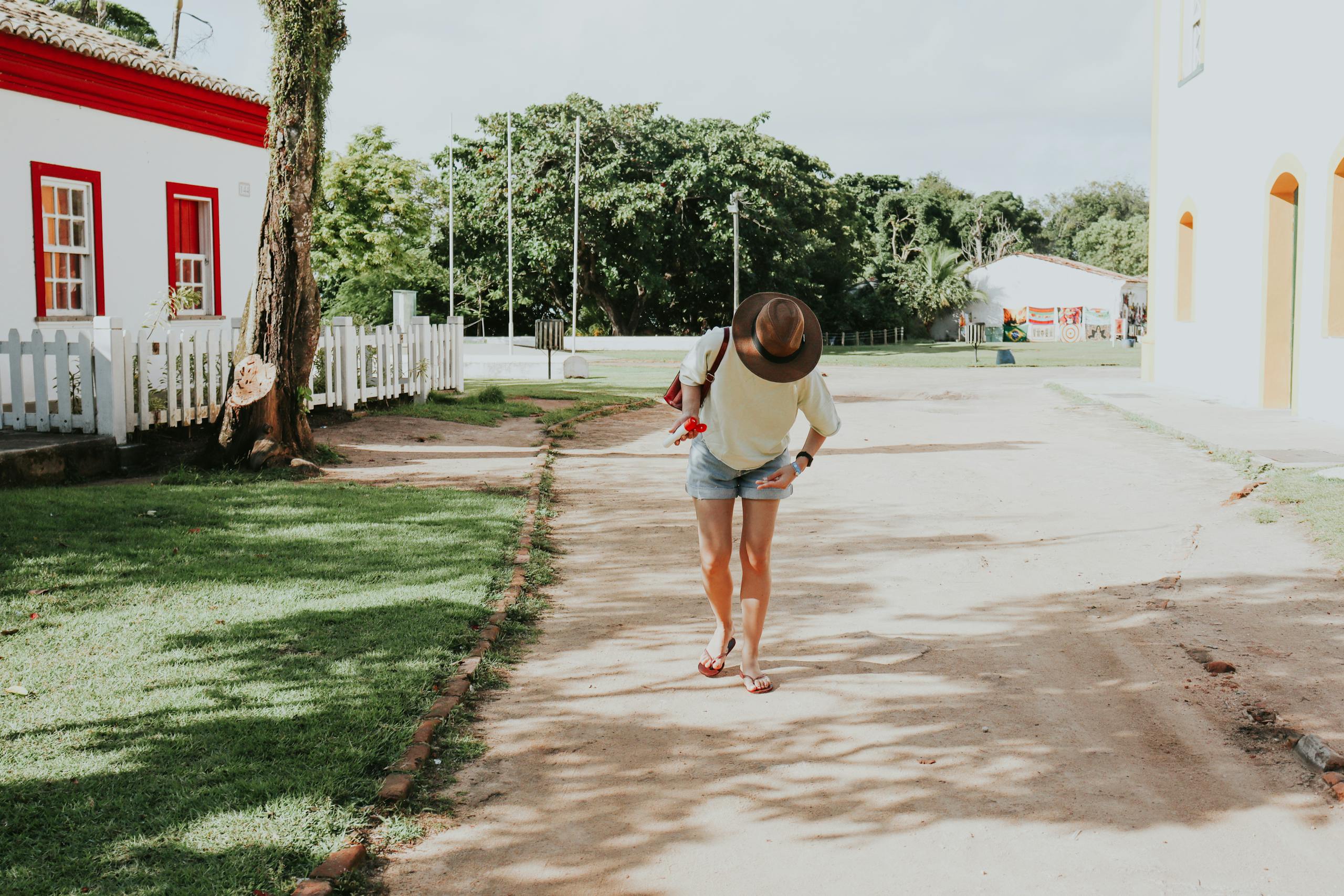 Eagles Rookie Trade Attempt Juntos Seguros ICEJuntos Seguros ICE A woman in casual attire walks down a sunny street in Porto Seguro, Bahia, Brazil.