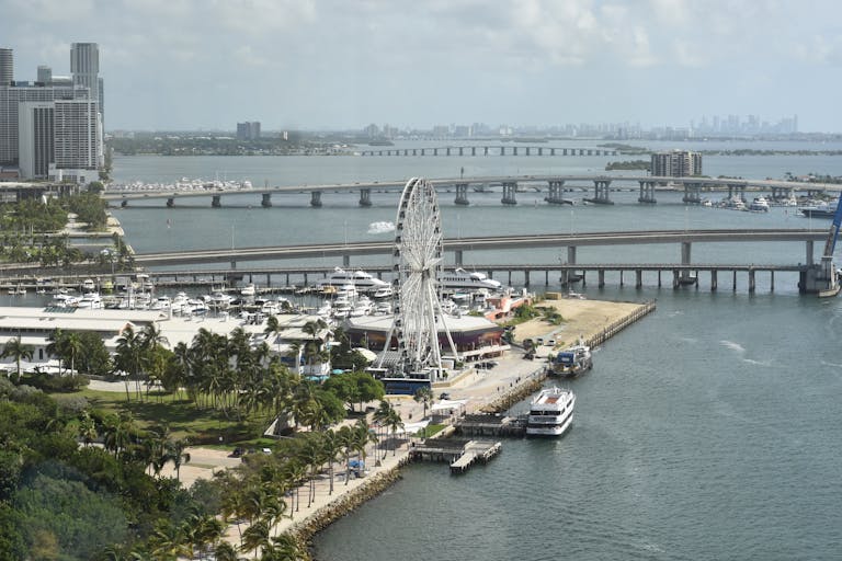 Sotwe Inter Miami Aerial shot of Miami's Ferris Wheel and waterfront with bridges and city skyline in view.