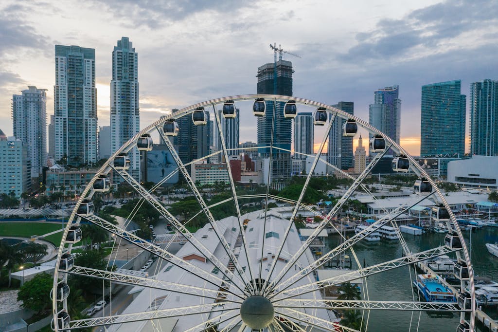 Inter Miami vs Tigres UANL Timeline Capture the vibrant Miami skyline from a Ferris wheel at dusk, featuring high-rise buildings and colorful urban landscape.