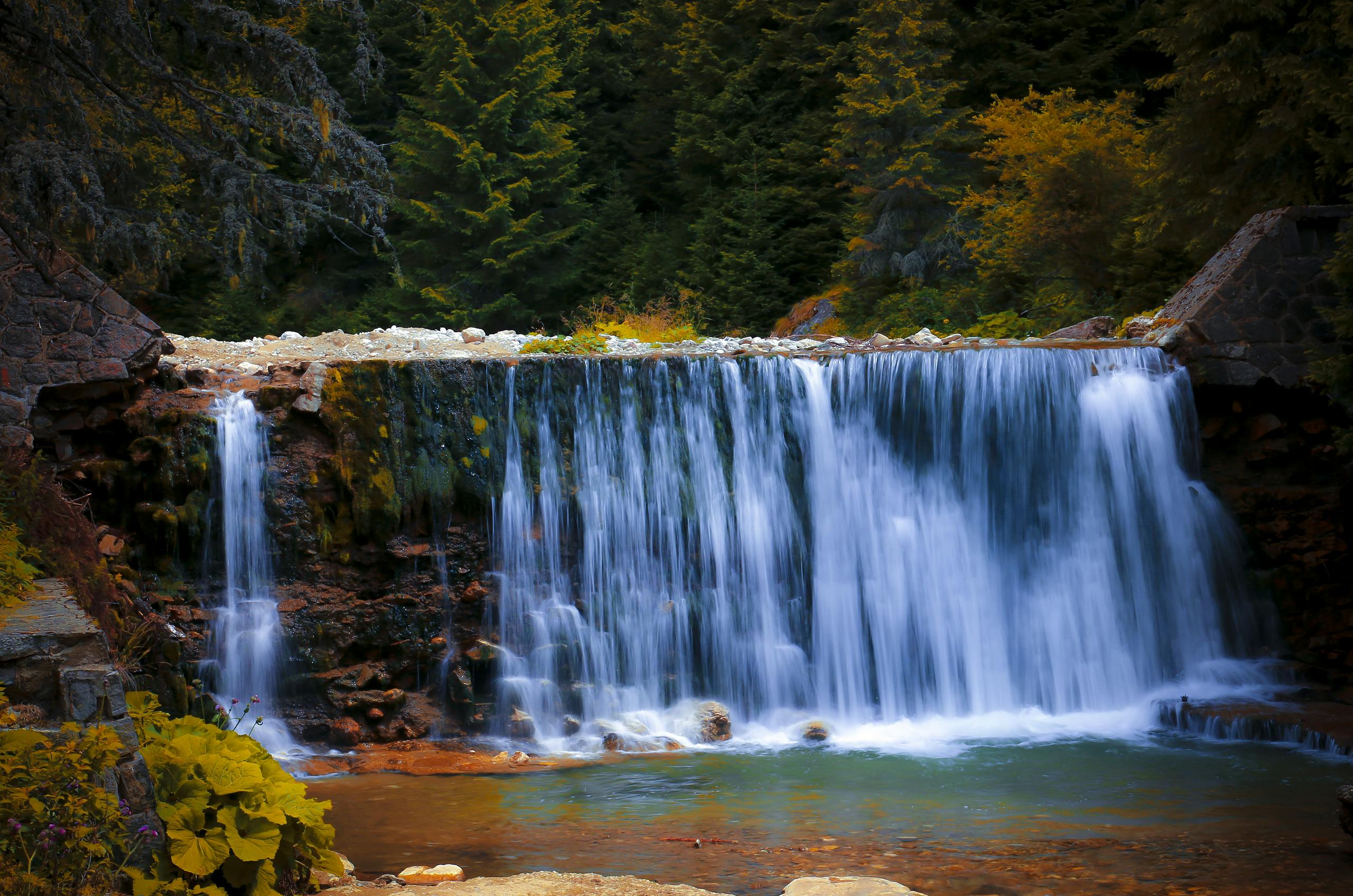 VALPLEKAR Cascading waterfall in a lush forest, capturing serene nature beauty.