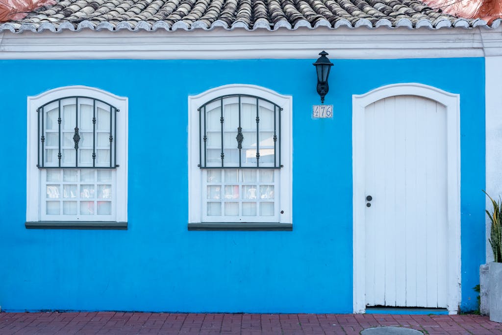 Juntos Seguros Charming blue facade of a house in Porto Seguro, Brazil with traditional windows and door.