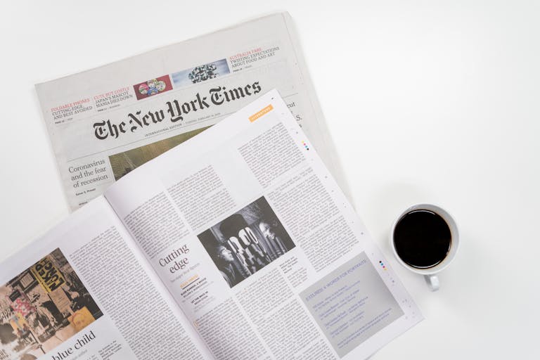 Newstook Flat lay of a coffee cup and The New York Times newspaper, ideal for business and lifestyle themes.
