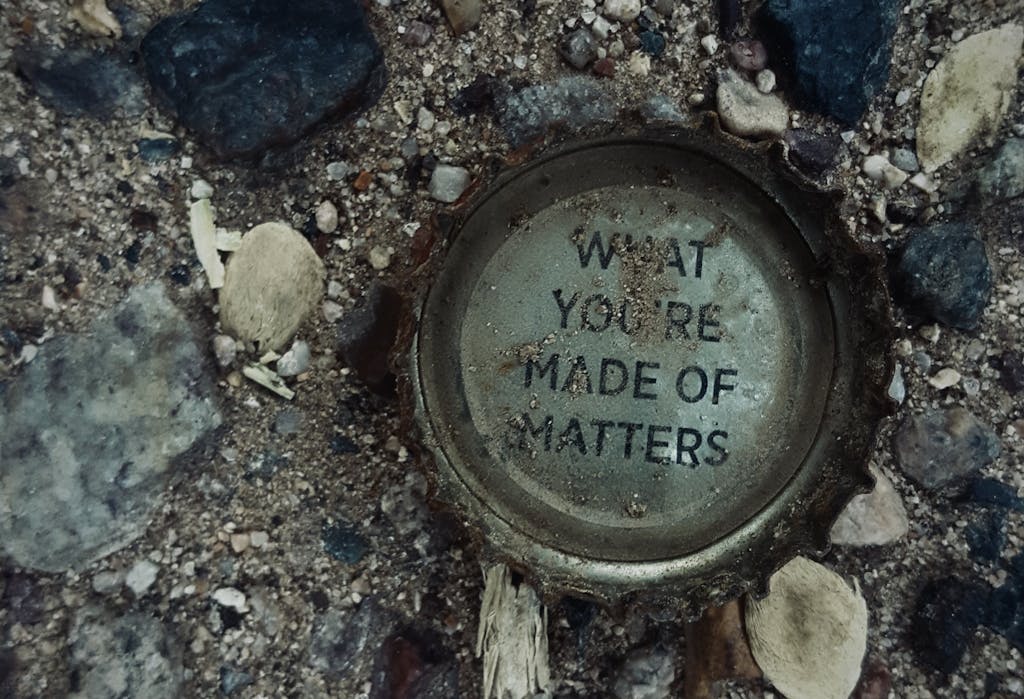  ChatPic Photograph of a rusty bottle cap on gravel with the message 'What You're Made Of Matters.'
