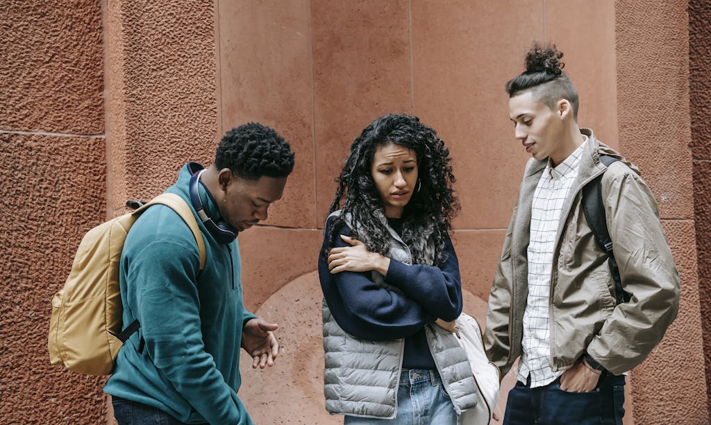 Miami Dolphins Three diverse teenagers talking against a textured wall.