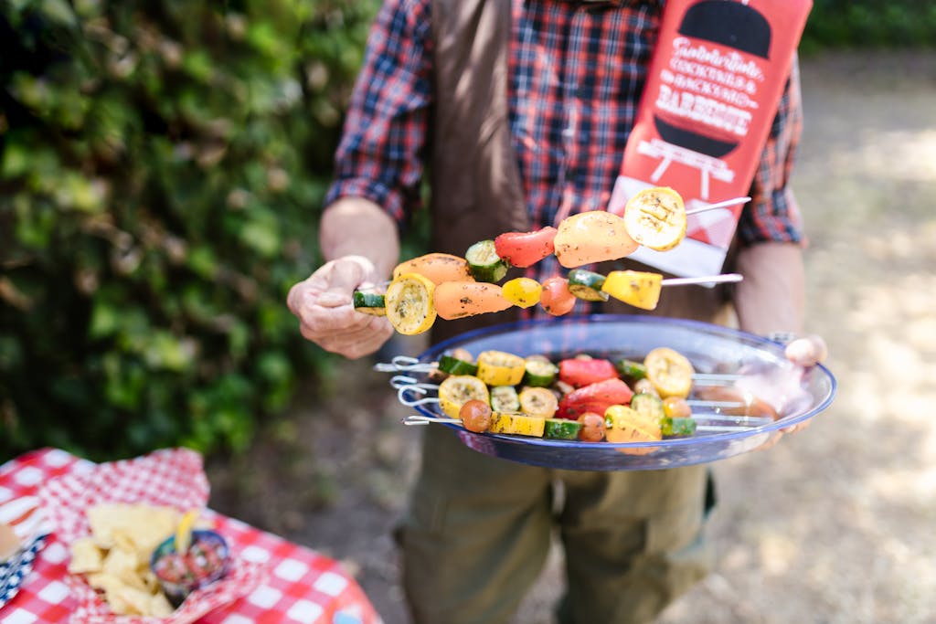Weber Grillvorführung Vibrant vegetable skewers being prepared at an outdoor barbecue during summer.